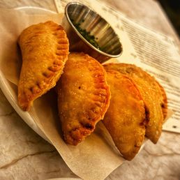 Dama signature dishes Calamari, Empanadas, Fried Chicken Tacos, Crispy Pork Shank.
